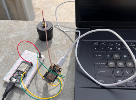 esp32 on a breadboard wired to an rtk gps module and antenna outdoors
